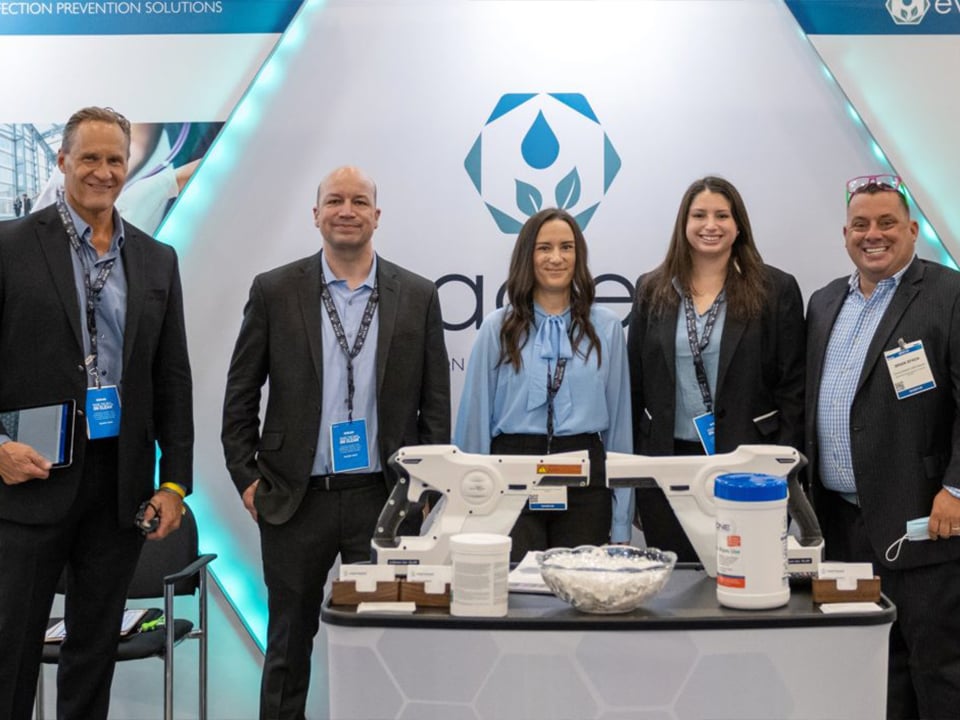 EvaClean team with electrostatic sprayer at tradeshow table